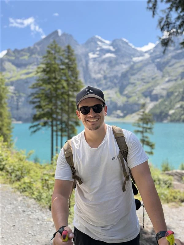 Paul Moos auf einer Wanderung vor Berglandschaft und See